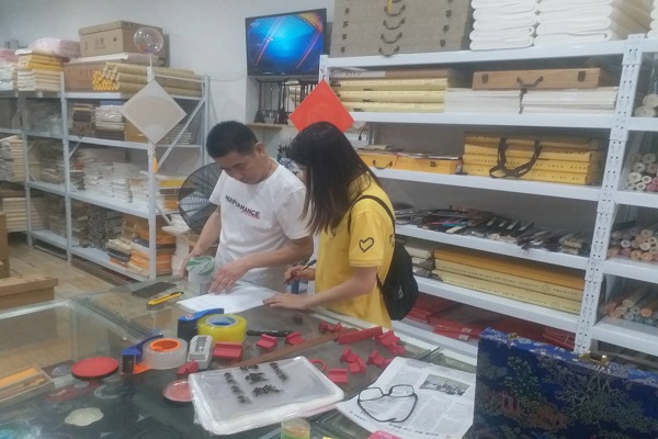 图为团队成员采访宣纸店主 图为团队成员采访宣纸店主